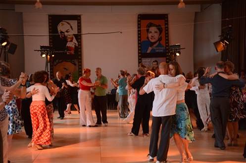 A group of people dancing in a room

Description automatically generated